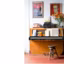 Un piano, un tabouret et des affiches anciennes