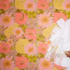 Man painting over floral wallpaper