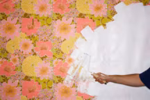Man painting over floral wallpaper