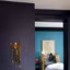 Une peinture aubergine en contraste avec le bleu de la chambre
