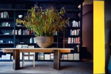 A gauche: Table "Zor" en laiton et chêne massif teinté. A droite: Christophe Delcourt.