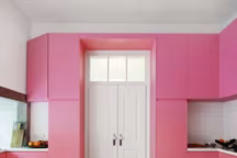 Proche du rose persan, le rose gourmand de la cuisine dynamise l'espace d'une note féminine face à l'harmonie candide de la salle à manger.