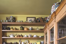 Dans la cuisine aux couleurs du Sud, sur les étagères une collection de céramiques de Vallauris, Menton ou Marseille, et vaisselier en sapin XVIIIe finlandais.