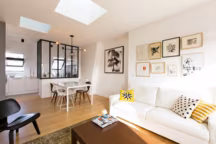 Un salon lumineux avec cuisine verrière dans cet appartement signé Philippe Demougeot - Côté Maison Projets