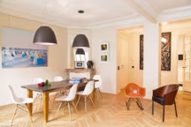 Dans la salle à manger ouverte sur le salon, la table des propriétaires flirtent avec des chaises Eames blanche et des suspensions contemporaines.