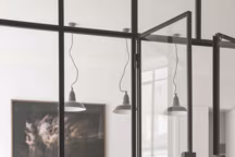 Vue de la cuisine vers la salle à manger. Des portes à battant s'incrustent dans le dessin de la verrière atelier et disparaissent une fois celles-ci fermées.