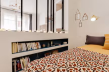 Le mur bas de cette petite chambre a été agrémenté de longues niches, idéales pour ranger ses livres et bibelots, sans perte de place. Aménagement Lara Grand.