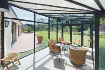 Dans cet espace vitré, la sensation d'immersion dans le jardin est totale. En toiture, combinaison de panneaux vitrés et opaques. Vérancial.