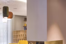 Fauteuils et suspensions vintage, poufs aux couleurs vives pour une pause dans le salon.