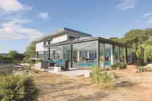 Avec une telle véranda, les propriétaires de cette maison située à Plougastel, profitent de leur piscine chauffée toute l'année. Bicoloration des menuiseries possible. Véranda Sérenity. Véranda Rideau.