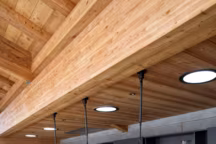 Traversée par la lumière, la maison en bois de la décoratrice Hélène Roux est posée à fleur de montagne. Discrète cabane d'observation plantée au pied des Carroz, elle fait corps avec l'environnement pour offrir la quiétude de l'altitude.--Volontairement neutre, éclairée par des Sun Tunnel (Velux), la cuisine tout en longueur en mélaminé noir et son mur en béton banché. Au fond, fours (Gaggenau). La longue table-comptoir accueille sous son plateau le bloc du lave-vaisselle.