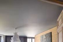 Dans cet appartement arty au coeur du Morvan, pas de perte de place dans la chambre aux tonalités douces d'une claire nuit d'été, avec un dressing dissimulé derrière la tête de lit en planches de bois du Morvan. Au mur, des tableaux signés Charlotte Smoos. La journée, la pièce est lumineuse, éclairée par deux portes-fenêtres et un oeil de boeuf.