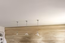 Dans le séjour salle à manger, canapé et fauteuil sur mesure de Charles Zana, table d'Antonio Citterio, B&B Italia, fauteuils et chaises "Lia", Zanotta, suspensions chinées à New York. Au sol, sculpture d'Annie Samuelson. Sur le mur, conçu en planches de peuplier, trois statuettes en bronze d'Anne Jaeckin et une œuvre en bois de Sonia Van Den Abeele.