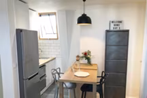 Masters Chaise Kartell x Philippe Starck. Table sur mesure. Réfrigérateur Samsung, 600 euros. Meubles de cuisine Cuisinella, 3000 euros. Suspension Fly. Carrelage effet béton Leroy Merlin.