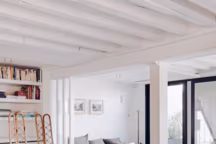 Banquette scandinave chinée aux puces de Saint-Ouen et chaises en rotin de la galerie Glustin, le tout datant des années 1950.