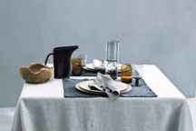 Nappe Bon, en lin lourd lavé, coloris perle, 170 x 170 cm, 225 euros ;
Set de table Drai, en toile de coton, coloris anthracite, 40 x 50 cm, 40 euros pièce ; Serviette Tab Fr, en lin léger frangé, coloris perle, 50 x 50 cm, 26 euros  pièce, Society Limonta.