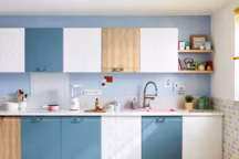 Cuisine Crystal bleu avec placards mixés Delinia Nordik finition bois et placards blancs facettés Origami, à partir de 626 euros la cuisine type et entre 20 et 50 euros la porte de cuisine. Plan de travail en stratifié blanc brillant, 179 euros, Leroy Merlin.