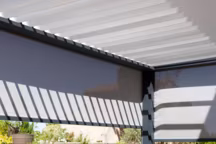 Grâce à une pergola bioclimatique, l'espace repas sur la terrasse est agréable à toute saison.