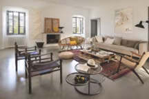 Au salon, au-dessus du canapé Caravane, photo de Virginie Harnois, Ipanema. Autour du tapis marocain, chauffeuse de Hans Wegner, fauteuils de campagne, banquette 1950 en osier, luminaires de Noguchi et lampadaire industriel chiné.