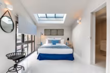 Plaques industrielles chinées, miroir rond Habitat, fauteuil en métal Nordal, coussins Westwing, lampe à poser It's about romi