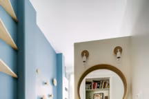 A gauche, sous les étagères sur mesure, un plan de travail et une machine à laver  ont pris place. De quoi créer un vrai coin buanderie bien pensé.