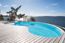 Piscine Céline en forme de haricot. Disponible en plusieurs dimensions : la longueur varie de 4,93 à 10,30 m et la largeur évolue proportionnellement de 3,44 à 6,60 m pour le côté le plus large, et de 2,31 à 4,10 m pour le côté opposé. Soit une surface pouvant aller de 13,2 à 52 m2. A partir de 7 310 euros, hors frais de pose, de livraison et options facultatives.