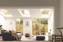 Les fenêtres de toit intégrées, grâce à leurs menuiseries blanches, fournissent un apport généreux de lumière naturelle zénithale à cette extension. Gamme Integra à motorisation électrique, fnition EverFinish, avec vitrage Tout Confort, Velux