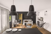 Filtrée par des rideaux en étamine de lin, une lumière douce pénètre la cuisine et le salon réunis en un seul volume. Renforcée par des plans noirs, la passion de la créatrice pour l'assemblage trouve là sa pleine expression. Canapé "Ghost", Gervasoni, coussins et pouf, Maison de Vacances, lampe, Mantis, appliques, Topos Workshop, cercles de lumière, Le Deun, cheminée au bioéthanol à poser.