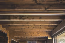 Côté salon, sur un tapis marocain, fauteuil Utrecht ; grande banquette en tissu Pierre Frey ; lampe Pipistrello, design Gae Aulenti ; canapé Caravane et au-dessus photo signée Martin d'Orgeval ; chauffeuse Updown ; rocking-chair et pouf Don Carlos ; tabouret en bois de cerf.