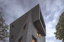 Un audacieux belvédère, monolithe aux formes géométriques assemblées, percé de baies multiples où le matériau privilégié â€“ le bois recouvert de bitume noir de Suède â€“ fait l'unité.