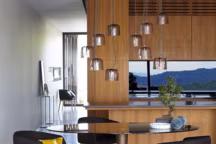 Table "Seona", plateau en verre trempé fumé  et piètement central en aluminium anodisé, aspect laiton vieilli, L170 x H75 x P100 cm, AMPM, 899 euros.