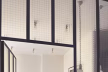 Installée dans l'ancienne cuisine, cachée par une verrière ouverte sur un couloir, la salle de bain de vient la pièce centrale de l'appartement. Sophie Hanniet lui offre un style maison de vacances en choisissant un carrelage à motifs très présents, Made a Mano.