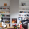 Côté Maison aime : l'insert de cheminée placé au centre d'une grande bibliothèque. Il apporte de la chaleur à la pièce et se fond totalement dans le décor.