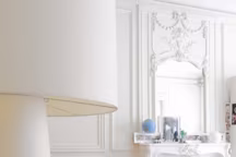 Dans le séjour, canapé cuir orange, Minotti chez Silvera, tapis, Ikea, lampadaire "Big Shadow Lamp" blanc de Marcel Wanders, devant la cheminée, rocking-chair "Dondola" de Pucci de Rossi et lampe noire chinée.