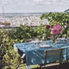 La table ombragée par un filet militaire face à la Tour Eiffel et au dôme de l'église Saint-Augustin.
