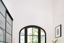 Magistrale, une porte-fenêtre format anse de panier en PVC laqué avec petits-bois incorporés. H 215 x L 160 cm.