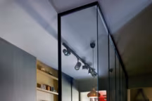 Abrité par une alcôve en transparence façon atelier, le coin repas est occupé par les tabourets de bar " Fil », Alias, une table en bois sur mesure, l'ensemble réalisé par Patrick Norguet ainsi que les revêtements des rangements Pure Paper " Color » pour Ober Surfaces. Miroir circulaire de Jacques Adnet, Gubi.