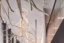 Surplombant le hall de réception, un plafond habillé d'arbres blancs évoquant les reflets de la forêt du Risoux sur le lac de Joux.