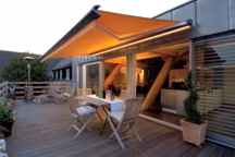 Ce store banne à lambrequin déroulable comporte un rail lumineux efficace pour l'éclairage de nuit. Il est proposé dans une grande variété de toiles et de couleurs (tous coloris RAL) avec la possibilité de laquer les armatures dans la même teinte. Commande manuelle ou automatisée par moteur filaire ou télécommandé. Capteur vent/soleil en option. Prix sur devis.