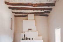 Cheminée graphique blanche  Dessinée par le Studio KO lors de la restauration de la ferme K33, cette cheminée est décorée de bougeoirs de Tamegroute, ville de potiers sur la route de Tombouctou.