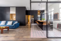 Les menuiseries créent du lien entre les différents espaces de la pièce. Ils sont un fil conducteur qui court du salon à la cuisine pour souligner le volume inédit.