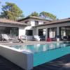 Piscine semi-enterrée réalisée en blocs à bancher, avec débordement sur parois vitrées, de forme trapèze, avec un escalier intérieur. 
Dim. : 8.30 x 3.80 x 2 m / Profondeur : 1.50 m (fond plat).Revêtement intérieur : membrane armée 150/100e coloris gris foncé.Filtration à sable. 2 pompes de filtration.Traitement de l'eau : électrolyseur au sel avec régulation pH. Chauffage : pompe à chaleur. Autres équipements : 1 projecteur. Appareil de nettoyage : balai hydraulique. Plages en bois composite. CARRE BLEU AGRETEC  A Artigues près Bordeaux (33); Architecte : Henri Blanchot