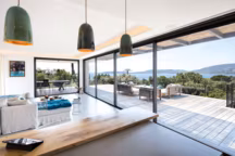 Faciles à manœuvrer grâce à leur système de levage, les coulissants à galandage " Vision » ménagent une vue à couper le souffle depuis le séjour de cette villa corse.