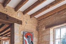 Les vieilles pierres mettent en valeur la peinture de l'artiste et le fauteuil Knoll revisité