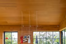 Sur mesure, table en teck massif. Pour alléger sa compacité, chaises " Fourmi » d'Arne Jacobsen et suspensions de Jacob E. Bang pour Fog & Morup. Au sol, échantillons de la designer.