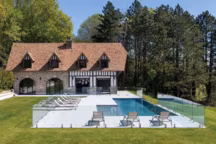 Double protection pour cette piscine à plage immergée, équipée d'un volet sous plage et de barrières de sécurité autour de la plage en pierre de Barcelone grise.