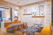 Ambiance intime avec 40 couverts en salle. L'atelier d'architecture Touton Studio a valorisé les éléments d'origine, parquet rustique et mur en pierre.