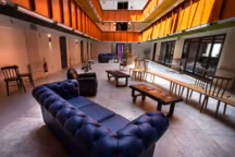 Canapé Chesterfield en cuir bleu océan, mobilier dessiné sur mesure par la société brestoise Edifix Créateurs, sol en béton ciré et dalles de pierre.