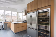 Style scandinave pour cette cuisine ouverte sur le salon et baignée de lumière naturelle. Les lignes sobres et la finition bois, omniprésente font de cette pièce à vivre une cuisine conviviale et contemporaine. Réalisation SK Concept.