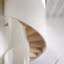 Un escalier colimaçon élégant en blanc et bois